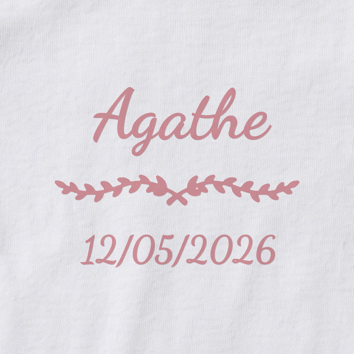 Body bébé personnalisé Agathe — gros plan du marquage « Agathe », ornement Liane et date de naissance « 12/05/2026 »