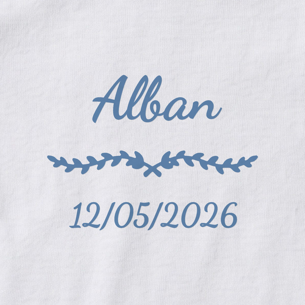 Body bébé personnalisé Alban — gros plan du marquage « Alban », ornement Liane et date de naissance « 12/05/2026 »
