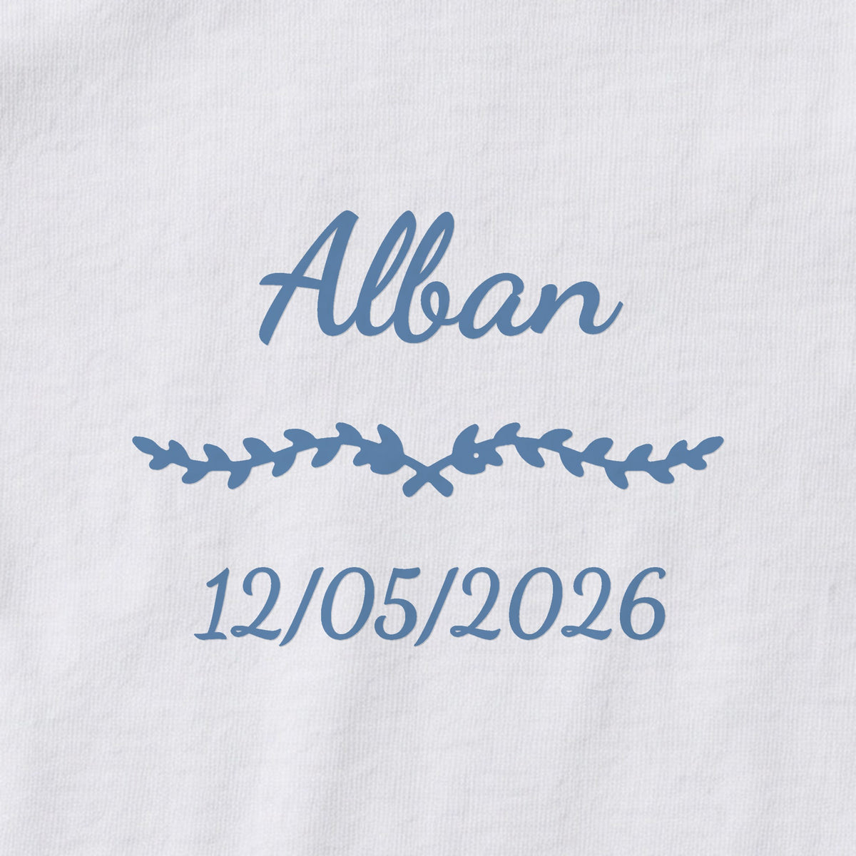Body bébé personnalisé Alban — gros plan du marquage « Alban », ornement Liane et date de naissance « 12/05/2026 »