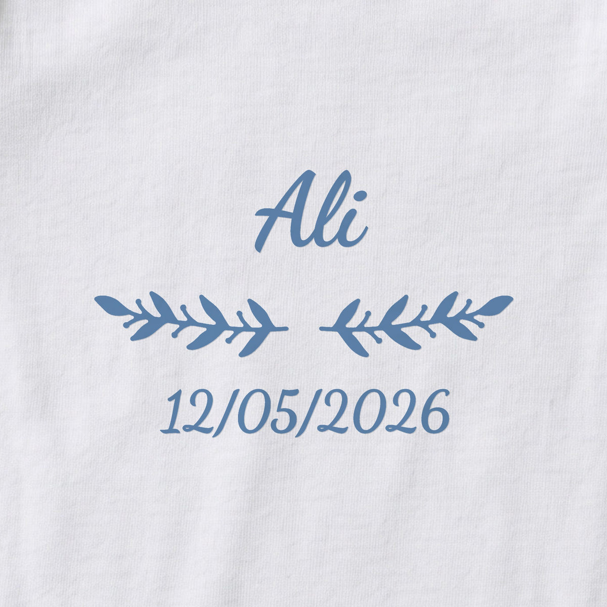 Body bébé personnalisé Ali — gros plan du marquage « Ali », ornement Rameaux et date de naissance « 12/05/2026 »