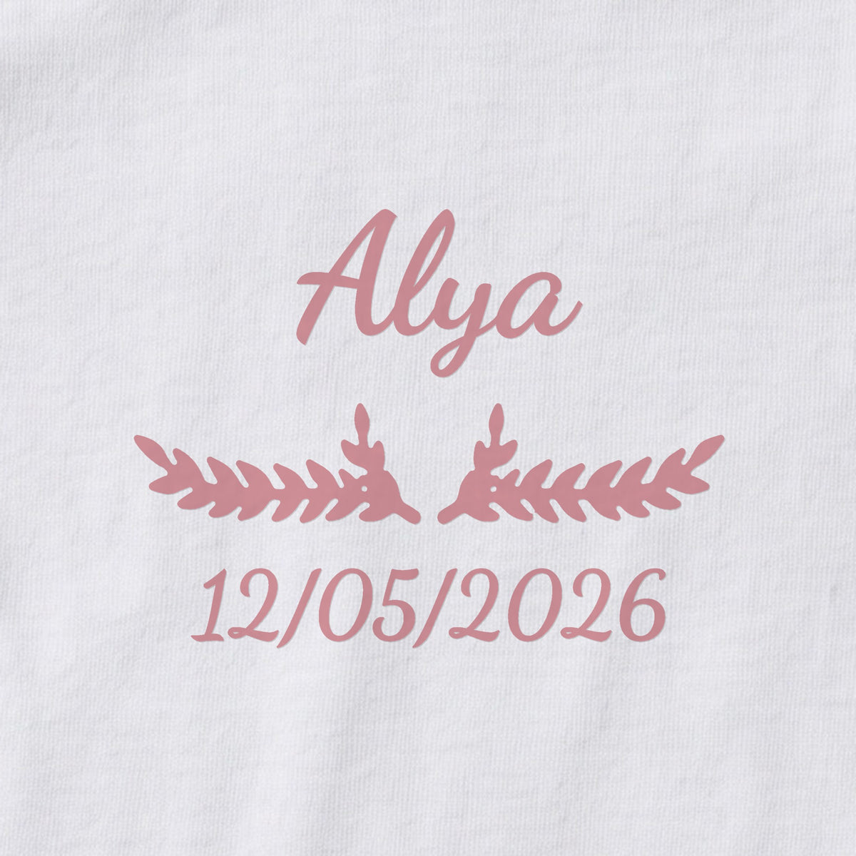 Body bébé personnalisé Alya — gros plan du marquage « Alya », ornement Bouquet et date de naissance « 12/05/2026 »