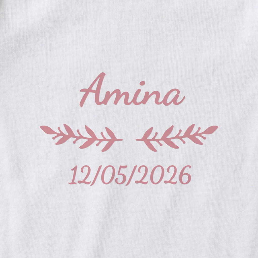 Body bébé personnalisé Amina — gros plan du marquage « Amina », ornement Rameaux et date de naissance « 12/05/2026 »