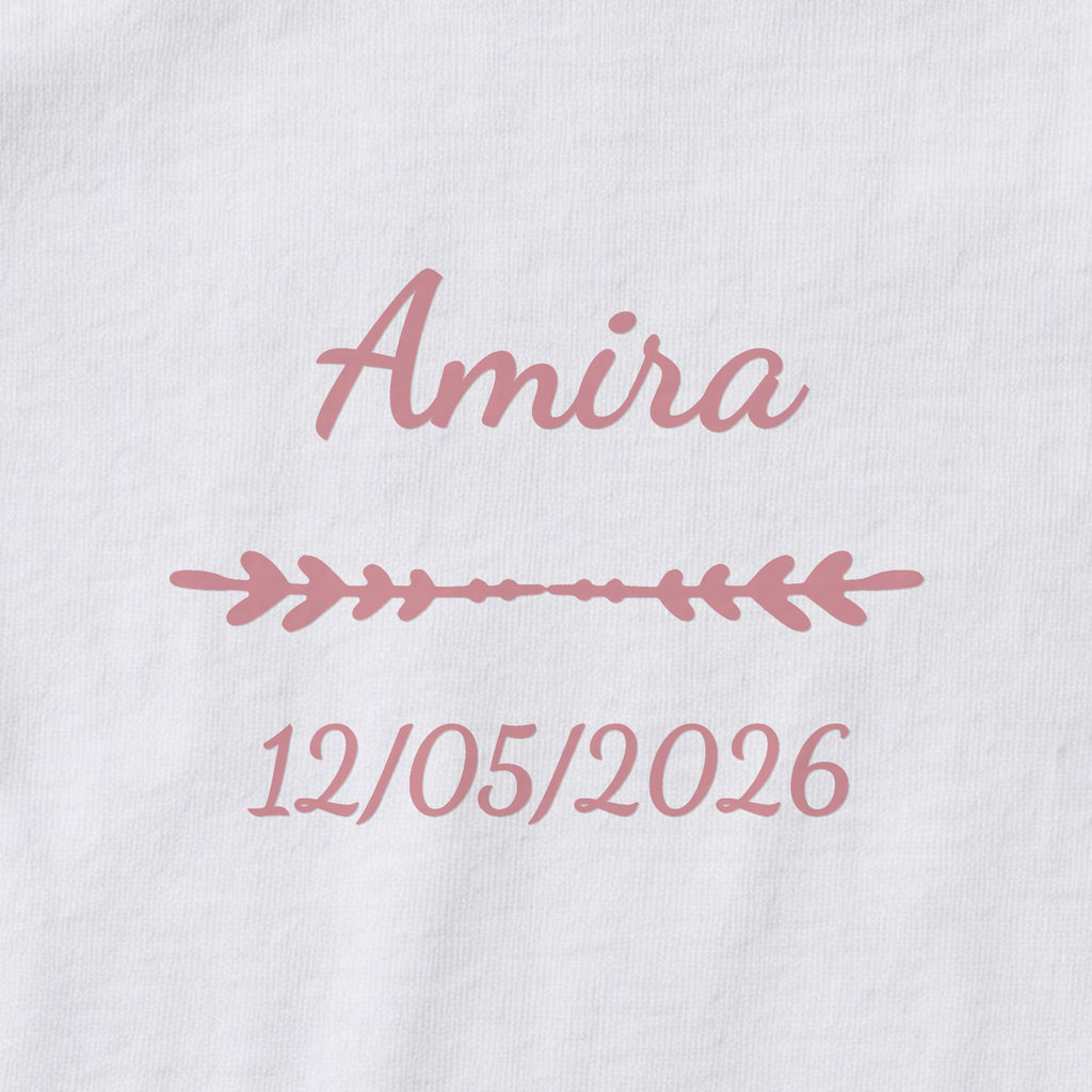 Body bébé personnalisé Amira — gros plan du marquage « Amira », ornement Flèche et date de naissance « 12/05/2026 »