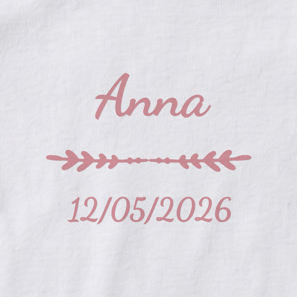 Body bébé personnalisé Anna — gros plan du marquage « Anna », ornement Flèche et date de naissance « 12/05/2026 »