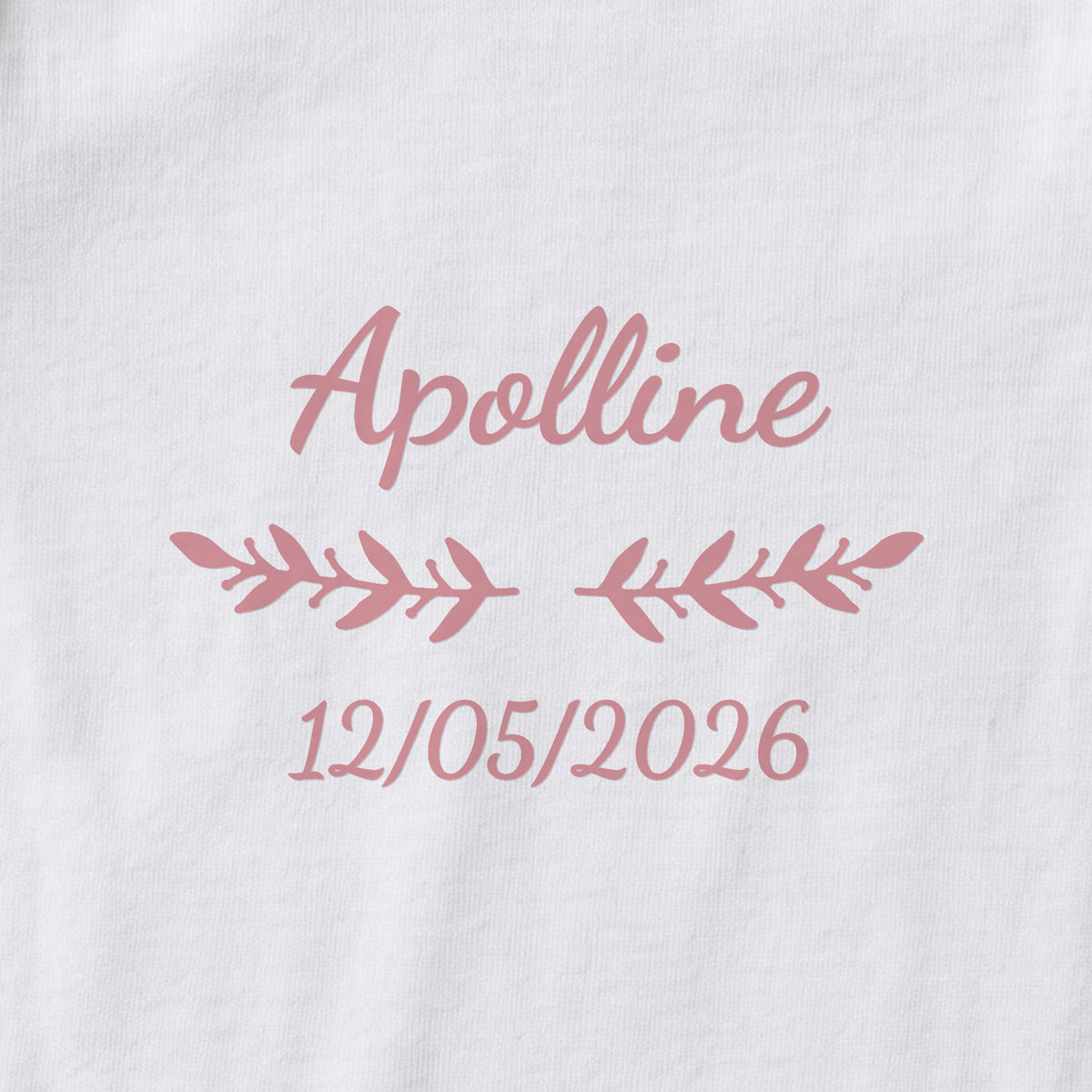 Body bébé personnalisé Apolline — gros plan du marquage « Apolline », ornement Rameaux et date de naissance « 12/05/2026 »
