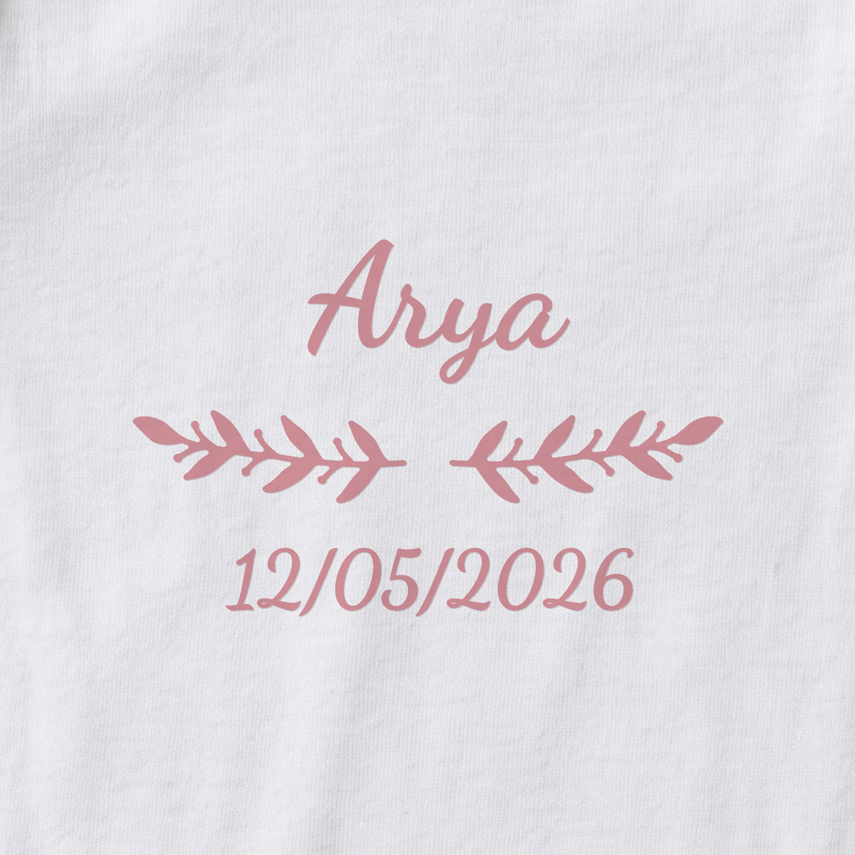 Body bébé personnalisé Arya — gros plan du marquage « Arya », ornement Rameaux et date de naissance « 12/05/2026 »