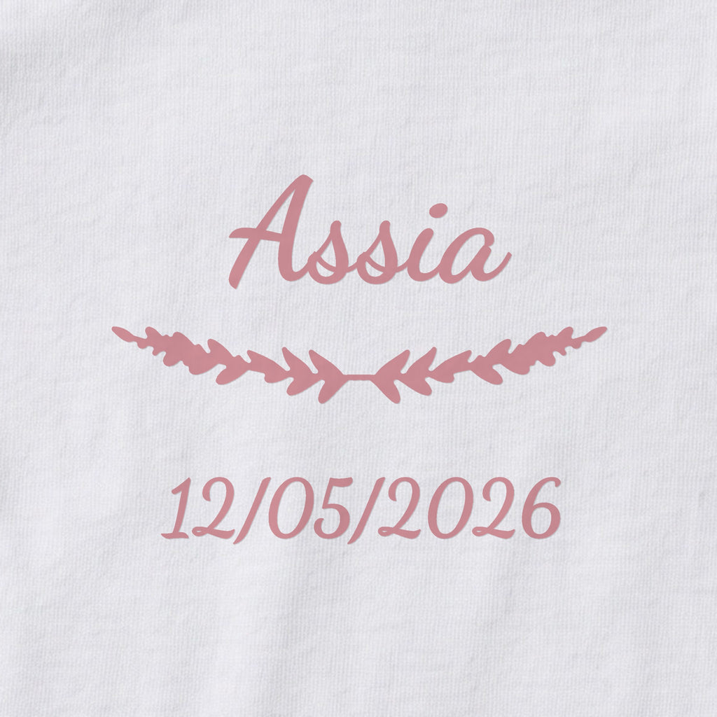 Body bébé personnalisé Assia — gros plan du marquage « Assia », ornement Brindilles et date de naissance « 12/05/2026 »
