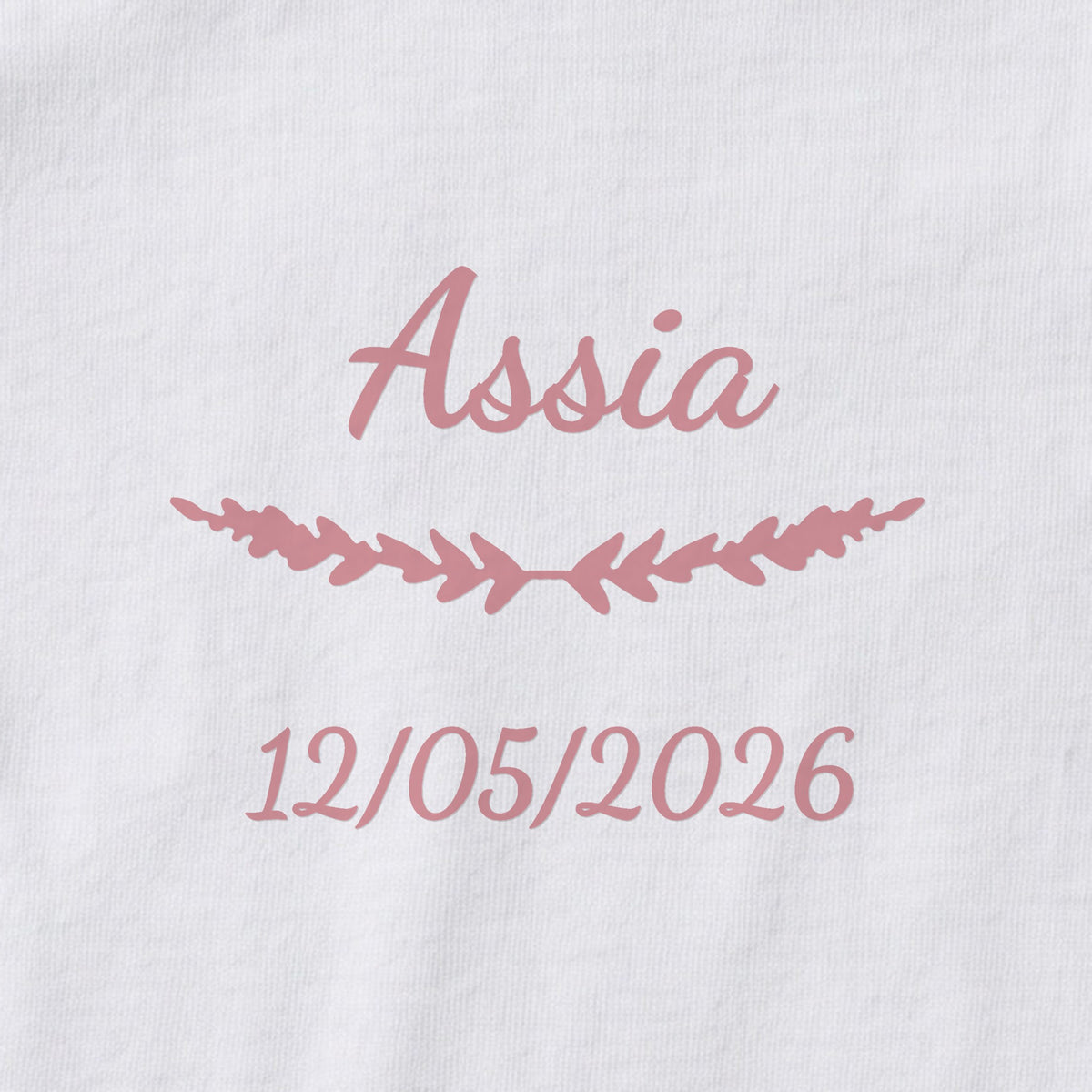 Body bébé personnalisé Assia — gros plan du marquage « Assia », ornement Brindilles et date de naissance « 12/05/2026 »