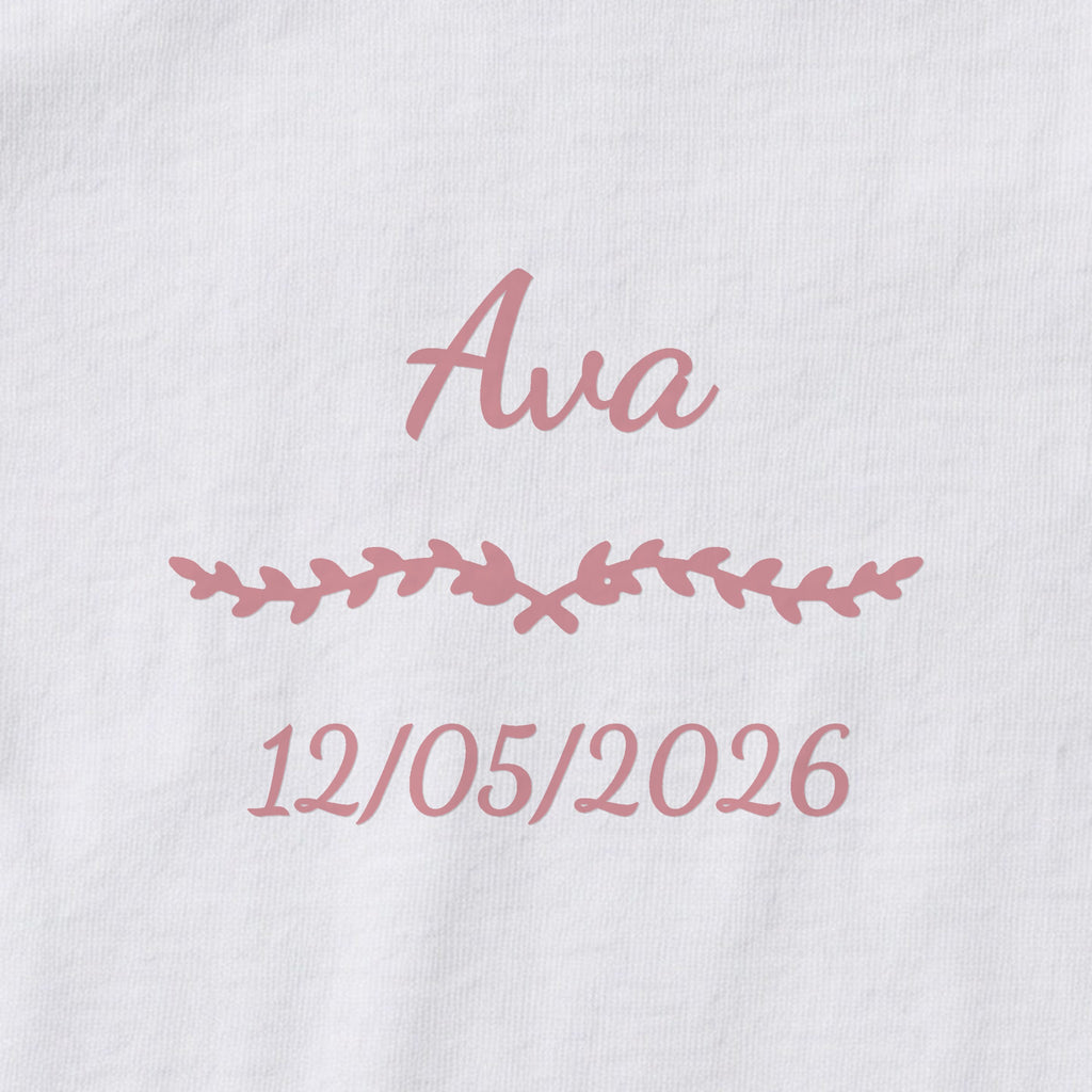 Body bébé personnalisé Ava — gros plan du marquage « Ava », ornement Liane et date de naissance « 12/05/2026 »
