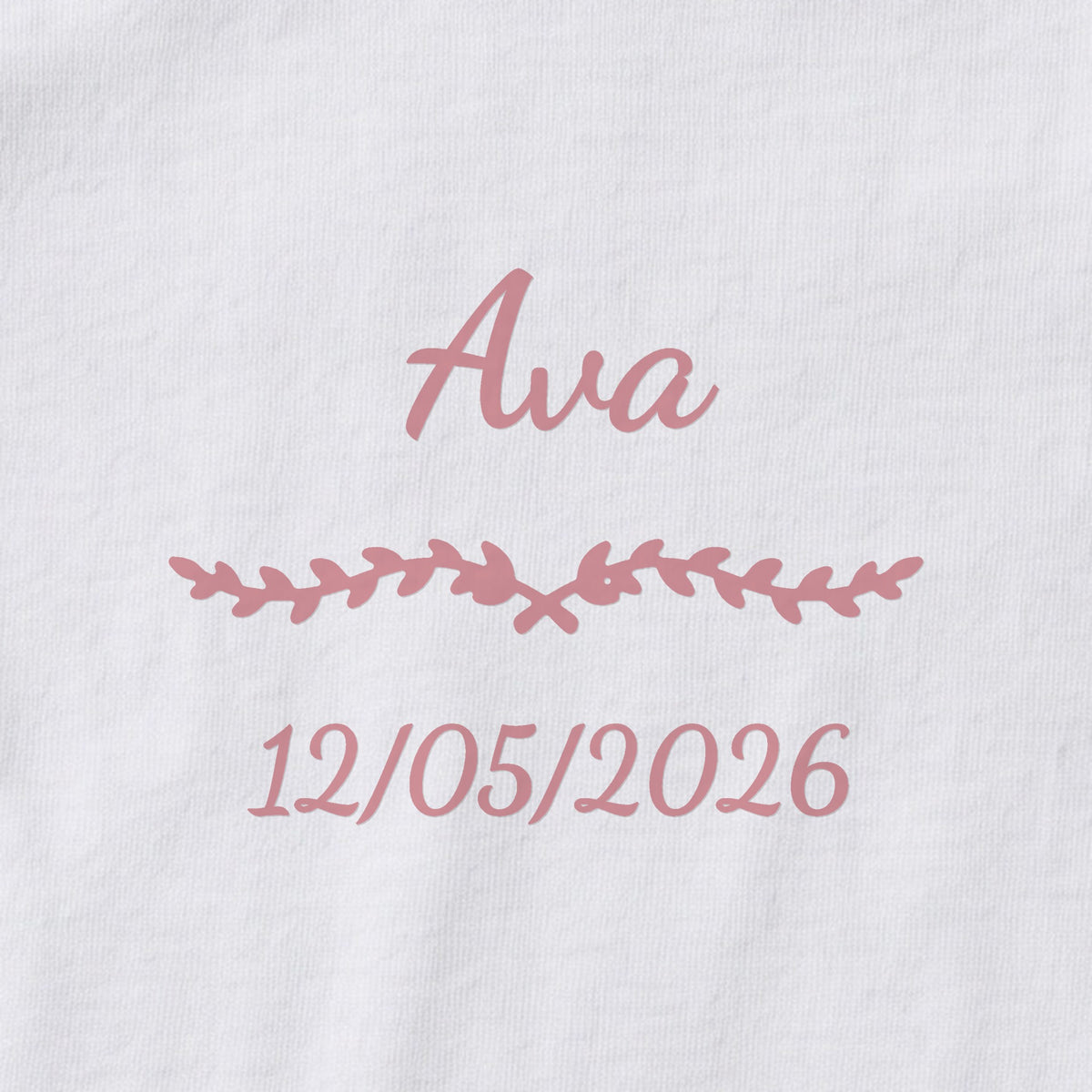 Body bébé personnalisé Ava — gros plan du marquage « Ava », ornement Liane et date de naissance « 12/05/2026 »