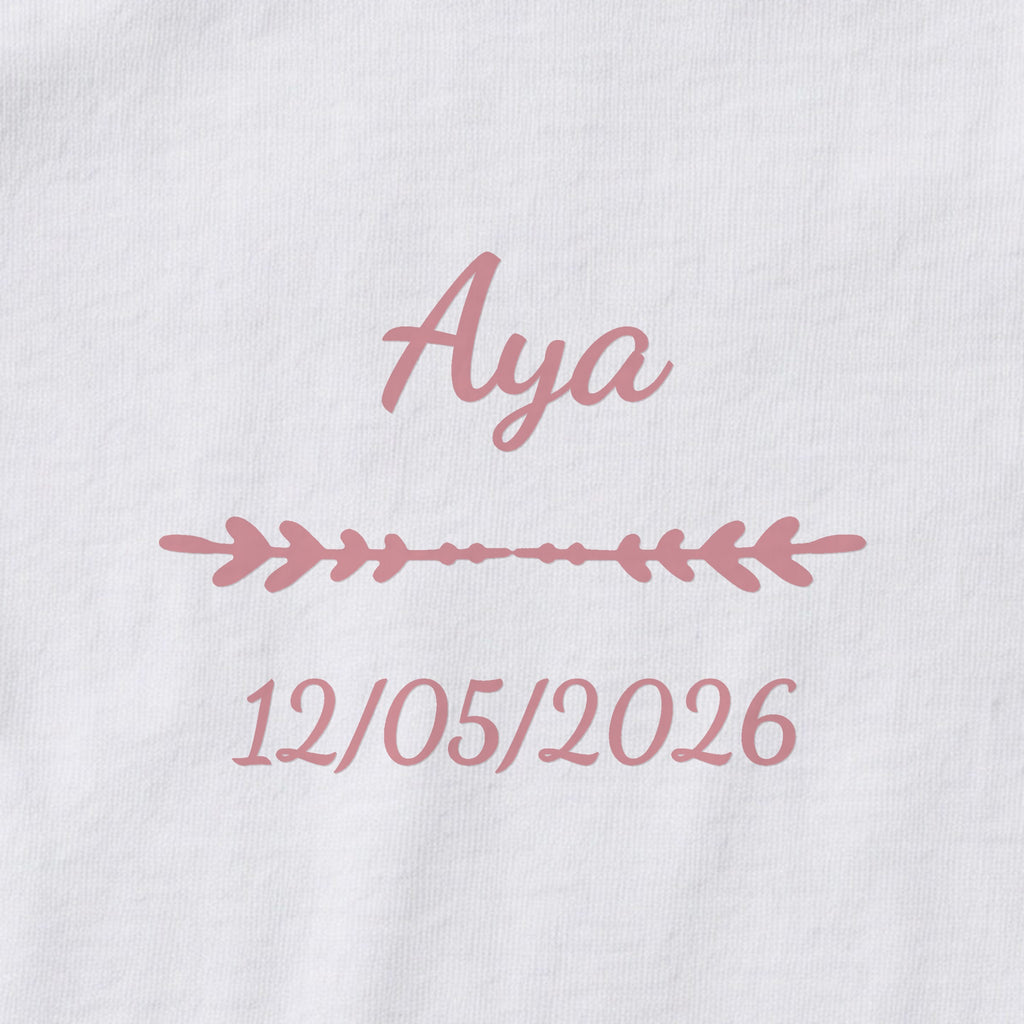 Body bébé personnalisé Aya — gros plan du marquage « Aya », ornement Flèche et date de naissance « 12/05/2026 »