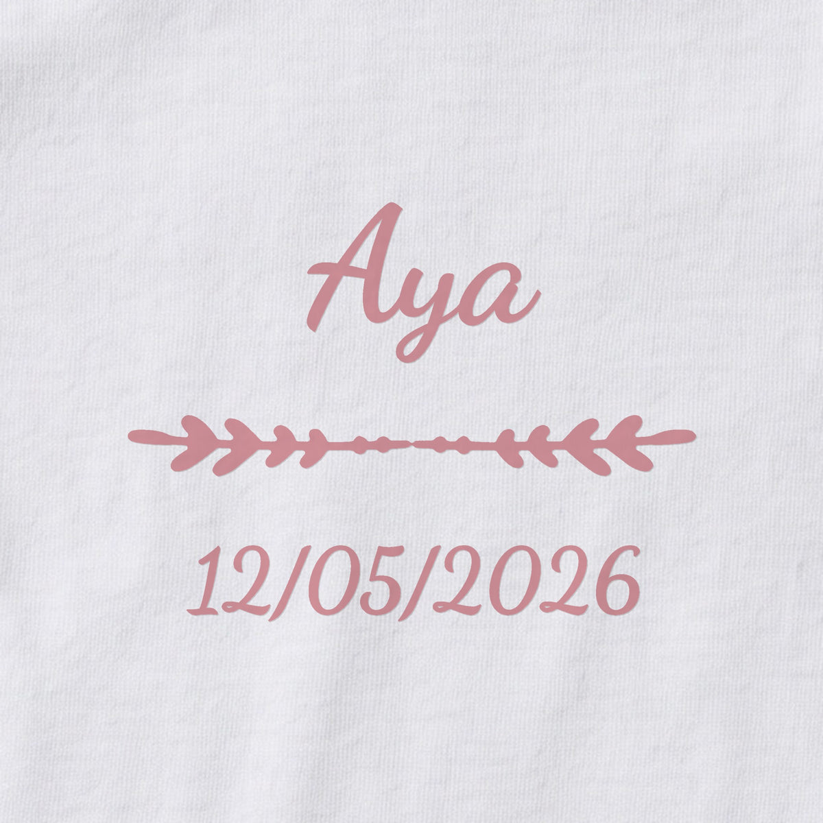 Body bébé personnalisé Aya — gros plan du marquage « Aya », ornement Flèche et date de naissance « 12/05/2026 »