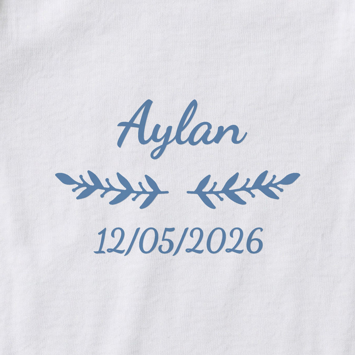 Body bébé personnalisé Aylan — gros plan du marquage « Aylan », ornement Rameaux et date de naissance « 12/05/2026 »