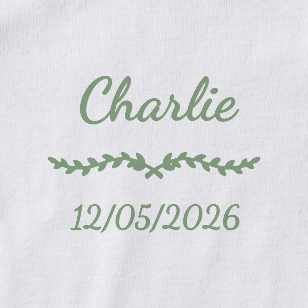Body bébé personnalisé Charlie — gros plan du marquage « Charlie », ornement Liane et date de naissance « 12/05/2026 »