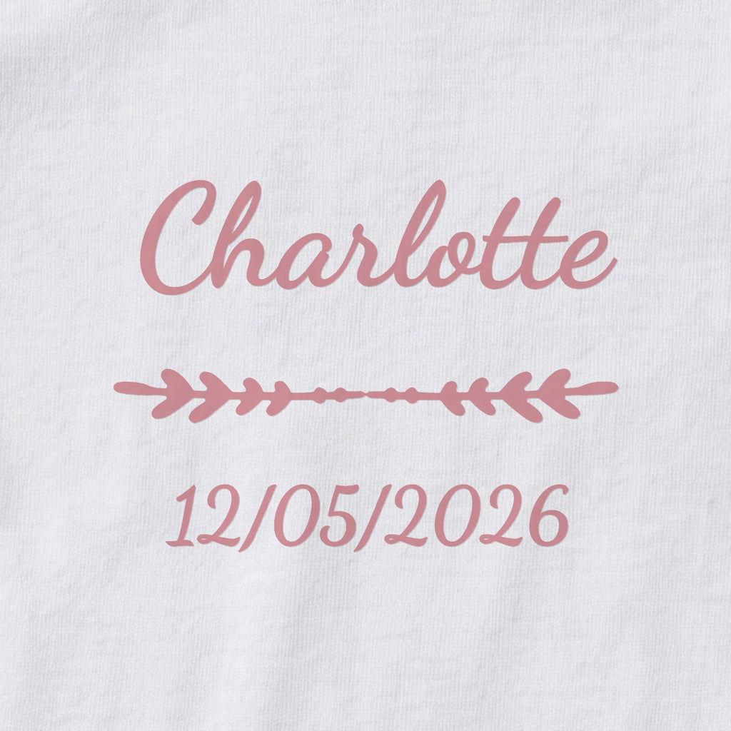 Body bébé personnalisé Charlotte — gros plan du marquage « Charlotte », ornement Flèche et date de naissance « 12/05/2026 »