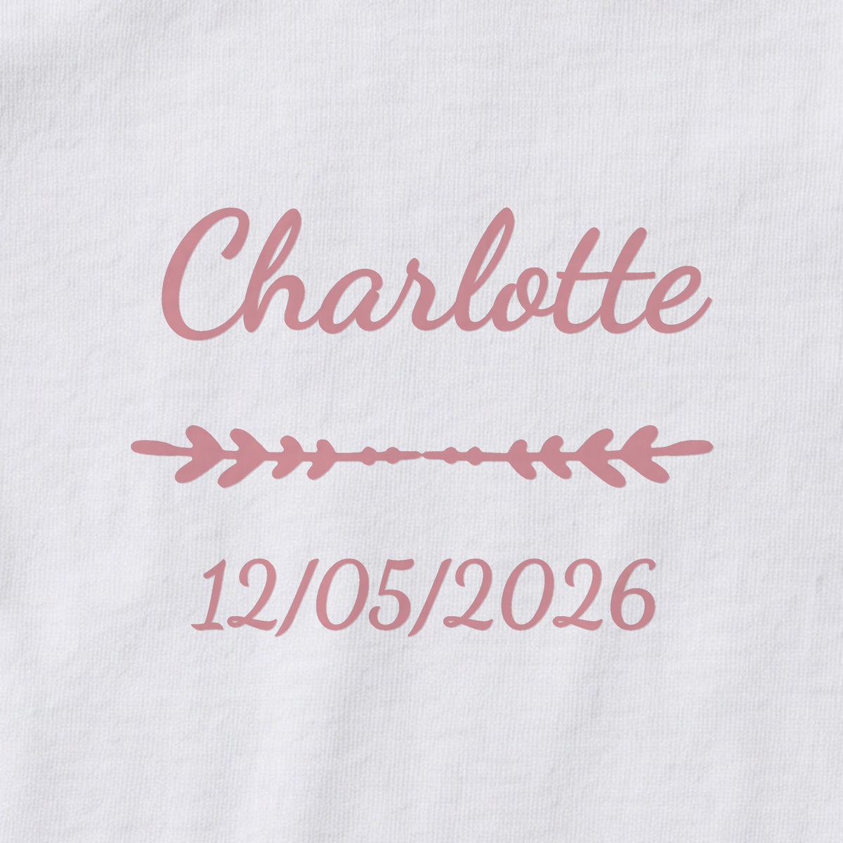 Body bébé personnalisé Charlotte — gros plan du marquage « Charlotte », ornement Flèche et date de naissance « 12/05/2026 »