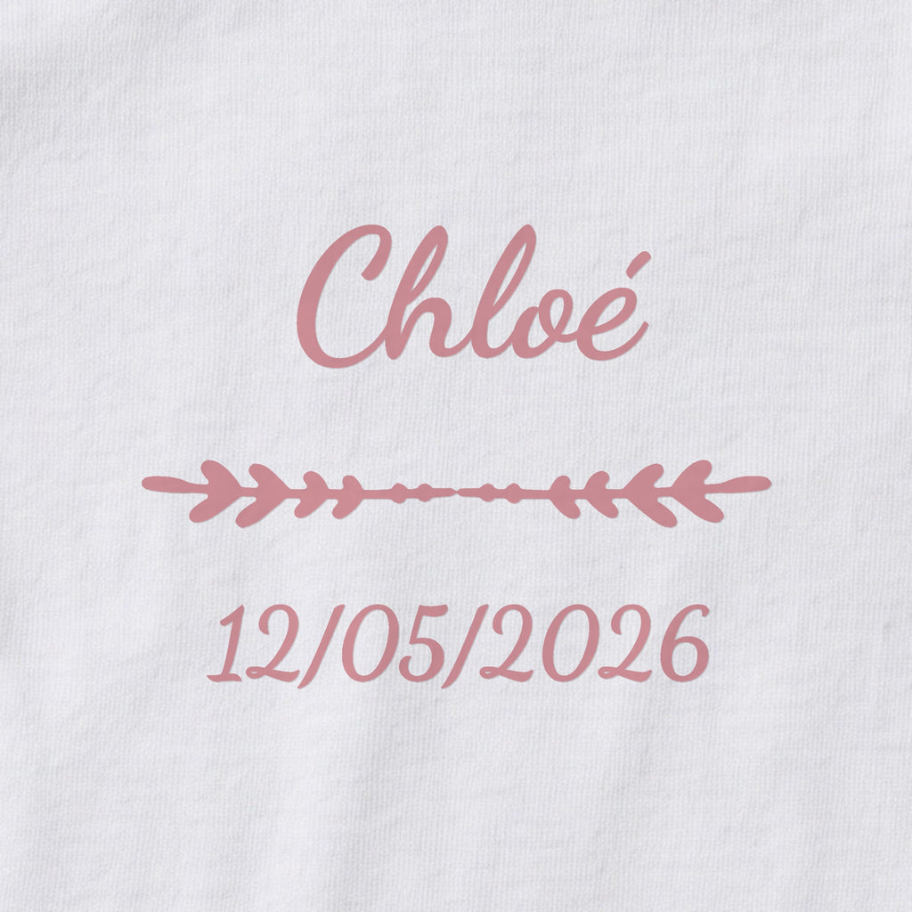 Body bébé personnalisé Chloé — gros plan du marquage « Chloé », ornement Flèche et date de naissance « 12/05/2026 »