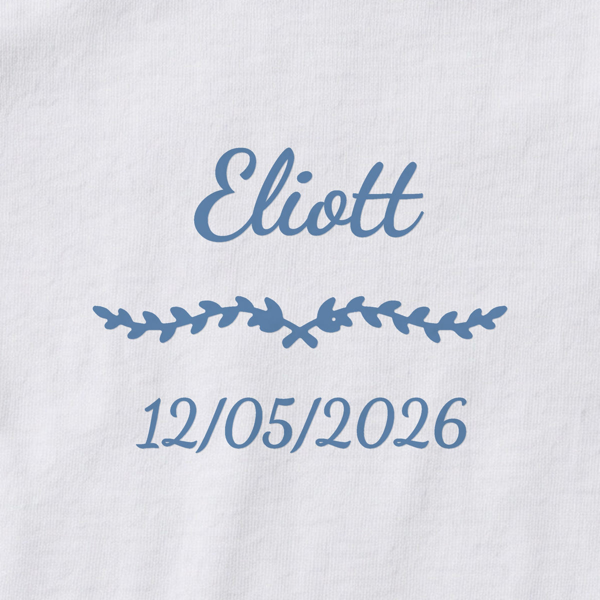 Body bébé personnalisé Eliott — gros plan du marquage « Eliott », ornement Liane et date de naissance « 12/05/2026 »