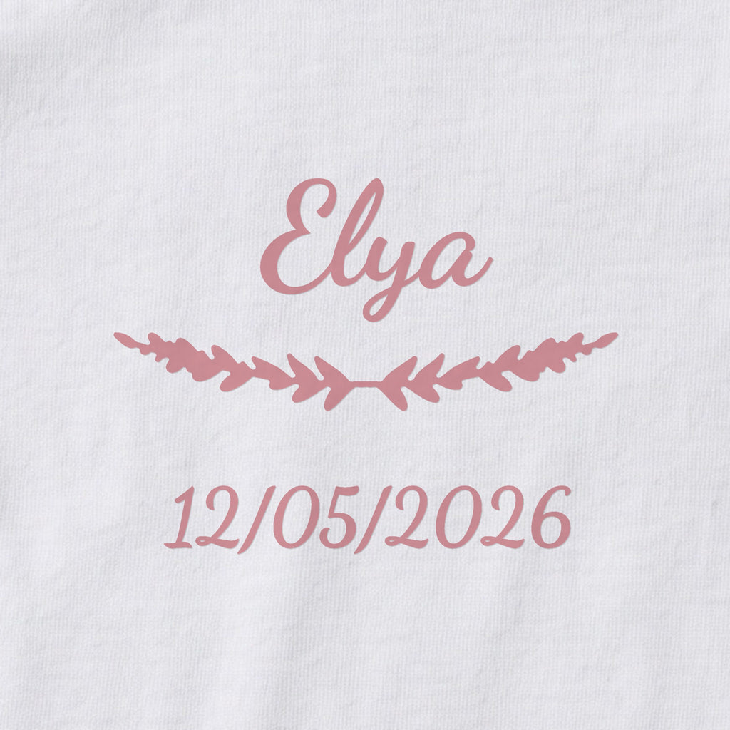 Body bébé personnalisé Elya — gros plan du marquage « Elya », ornement Brindilles et date de naissance « 12/05/2026 »