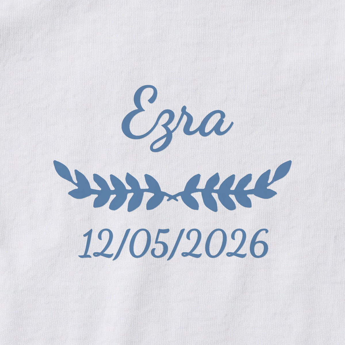 Body bébé personnalisé Ezra — gros plan du marquage « Ezra », ornement Feuillage et date de naissance « 12/05/2026 »