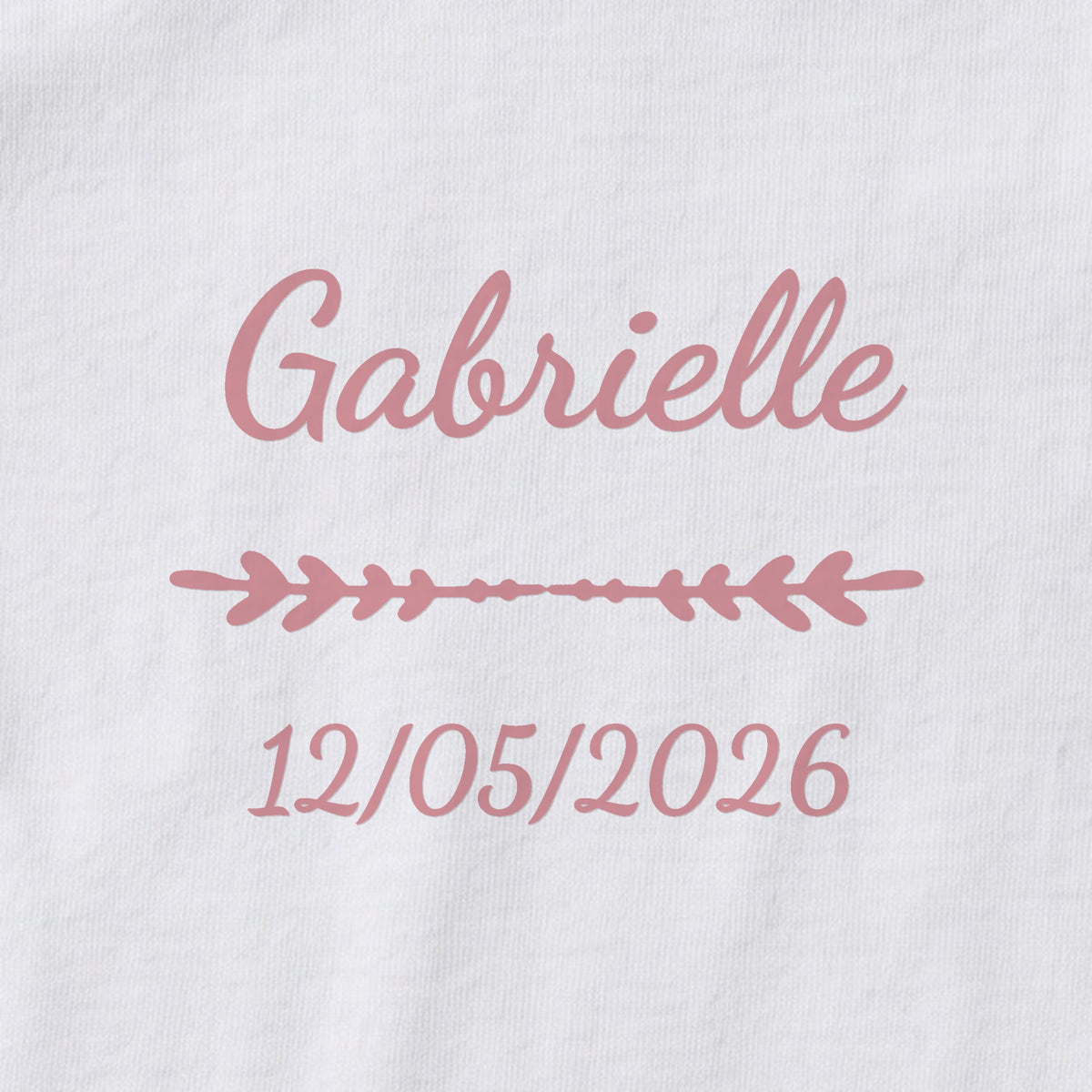Body bébé personnalisé Gabrielle — gros plan du marquage « Gabrielle », ornement Flèche et date de naissance « 12/05/2026 »