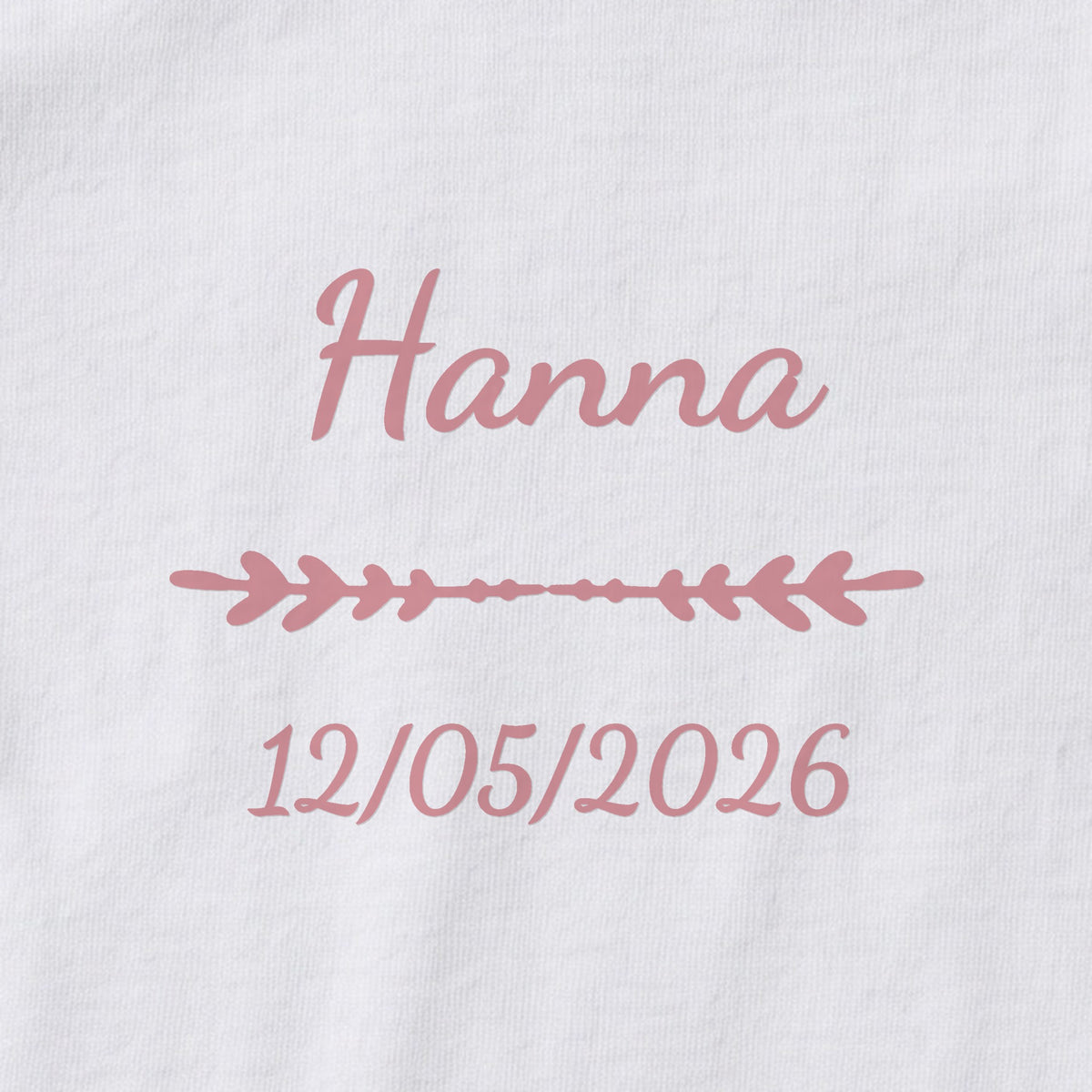 Body bébé personnalisé Hanna — gros plan du marquage « Hanna », ornement Flèche et date de naissance « 12/05/2026 »