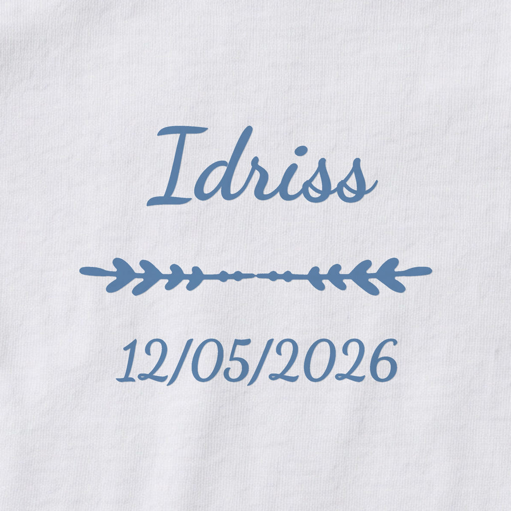 Body bébé personnalisé Idriss — gros plan du marquage « Idriss », ornement Flèche et date de naissance « 12/05/2026 »