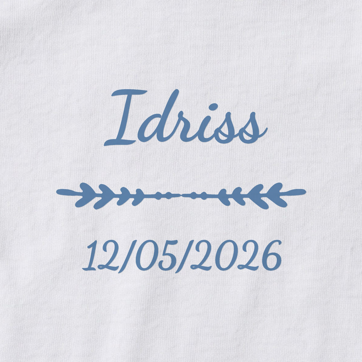 Body bébé personnalisé Idriss — gros plan du marquage « Idriss », ornement Flèche et date de naissance « 12/05/2026 »
