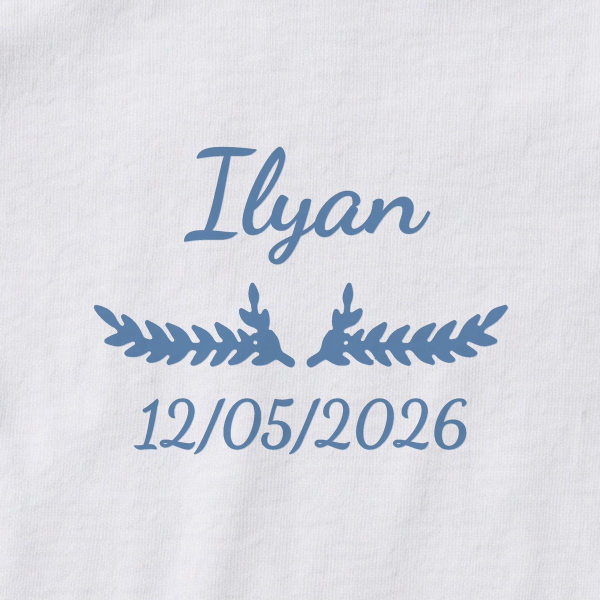 Body bébé personnalisé Ilyan — gros plan du marquage « Ilyan », ornement Bouquet et date de naissance « 12/05/2026 »