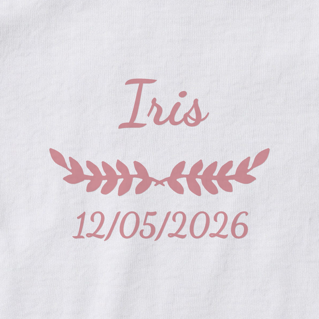 Body bébé personnalisé Iris — gros plan du marquage « Iris », ornement Feuillage et date de naissance « 12/05/2026 »