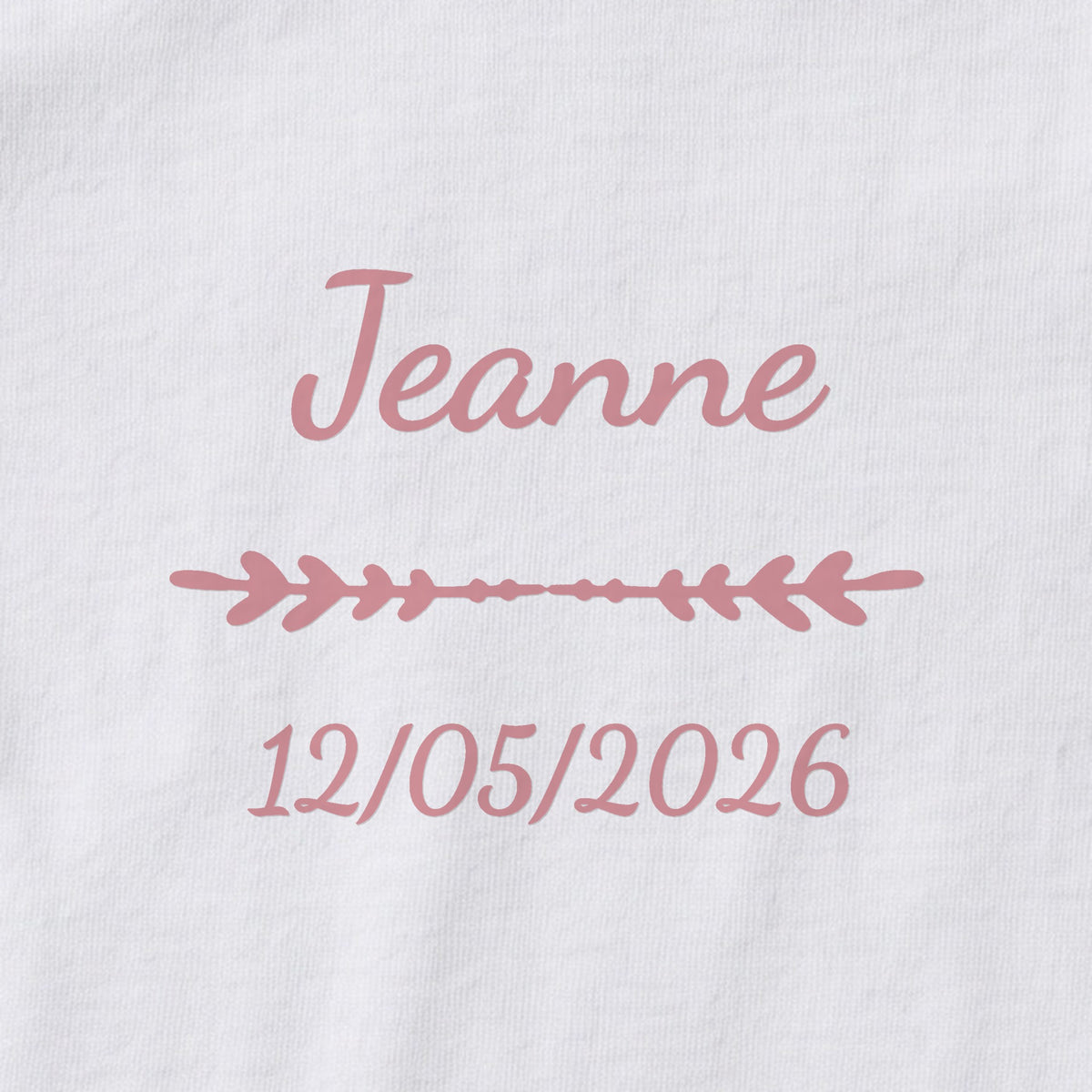 Body bébé personnalisé Jeanne — gros plan du marquage « Jeanne », ornement Flèche et date de naissance « 12/05/2026 »