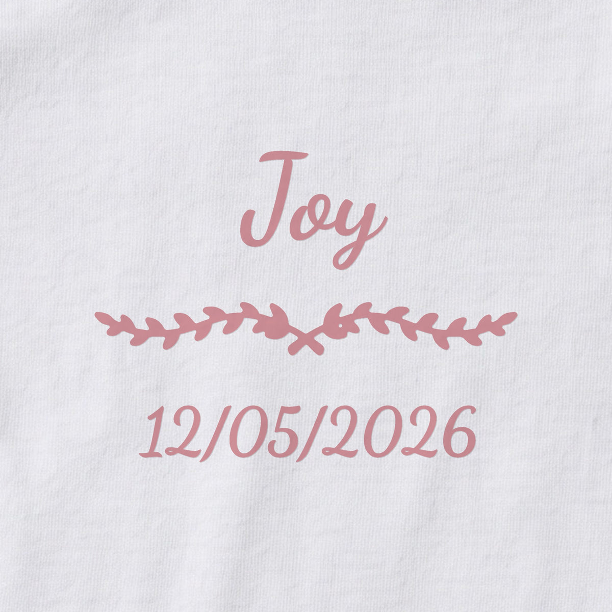 Body bébé personnalisé Joy — gros plan du marquage « Joy », ornement Liane et date de naissance « 12/05/2026 »