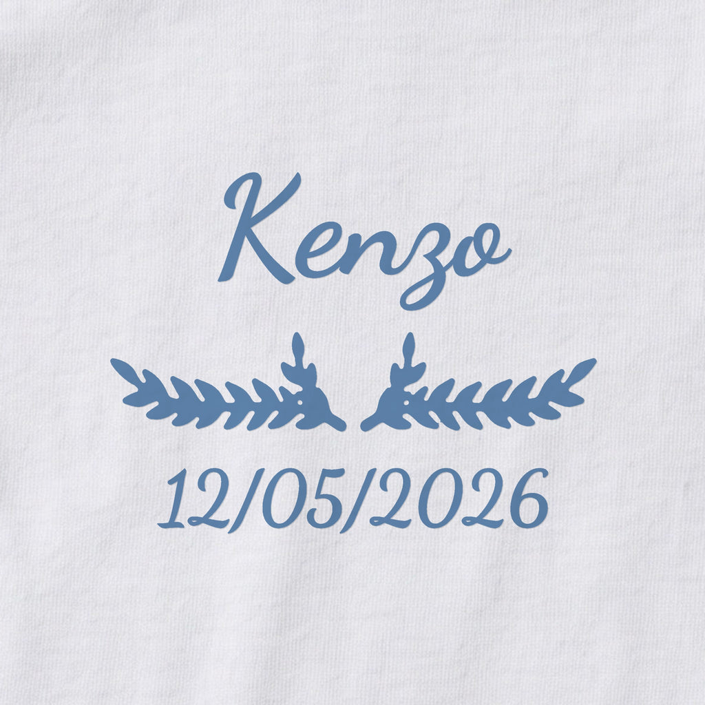 Body bébé personnalisé Kenzo — gros plan du marquage « Kenzo », ornement Bouquet et date de naissance « 12/05/2026 »
