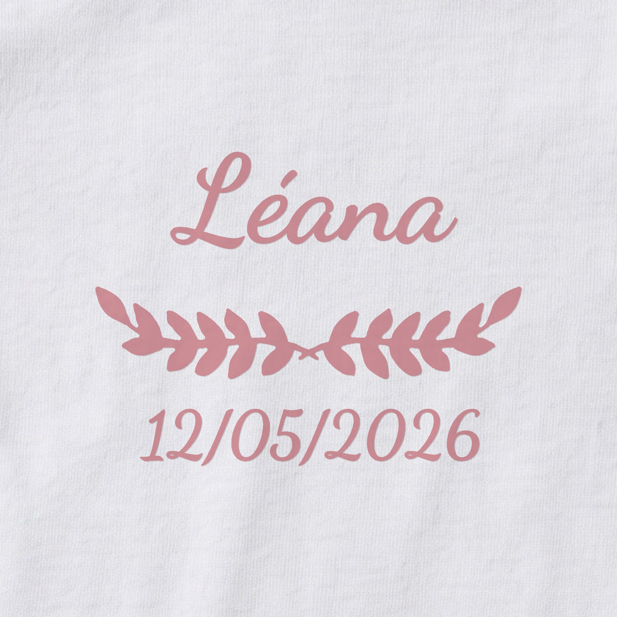 Body bébé personnalisé Léana — gros plan du marquage « Léana », ornement Feuillage et date de naissance « 12/05/2026 »