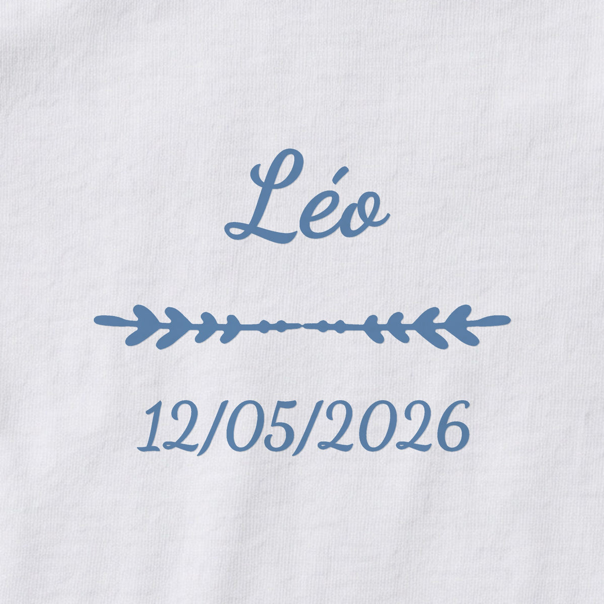 Body bébé personnalisé Léo — gros plan du marquage « Léo », ornement Flèche et date de naissance « 12/05/2026 »