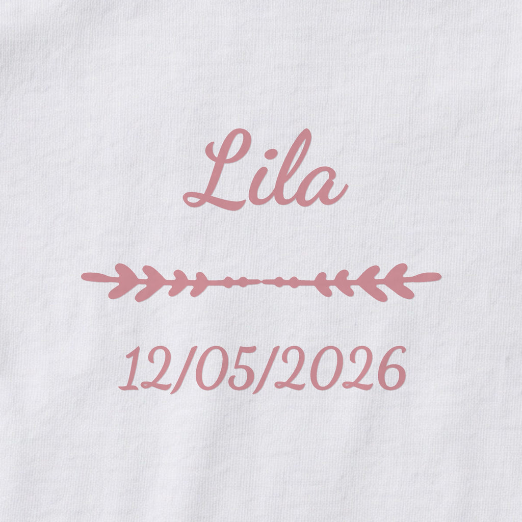 Body bébé personnalisé Lila — gros plan du marquage « Lila », ornement Flèche et date de naissance « 12/05/2026 »