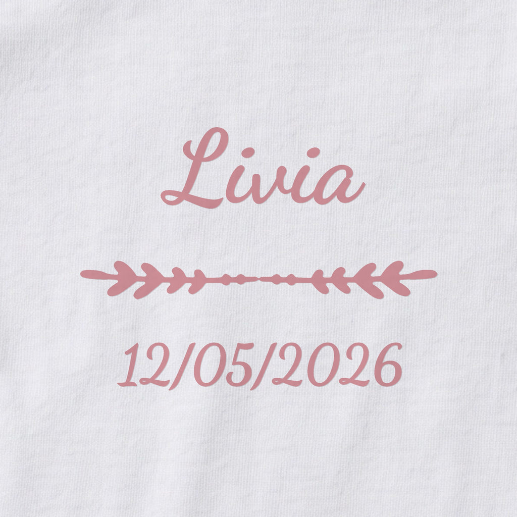 Body bébé personnalisé Livia — gros plan du marquage « Livia », ornement Flèche et date de naissance « 12/05/2026 »