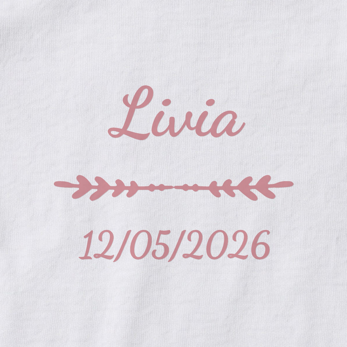 Body bébé personnalisé Livia — gros plan du marquage « Livia », ornement Flèche et date de naissance « 12/05/2026 »