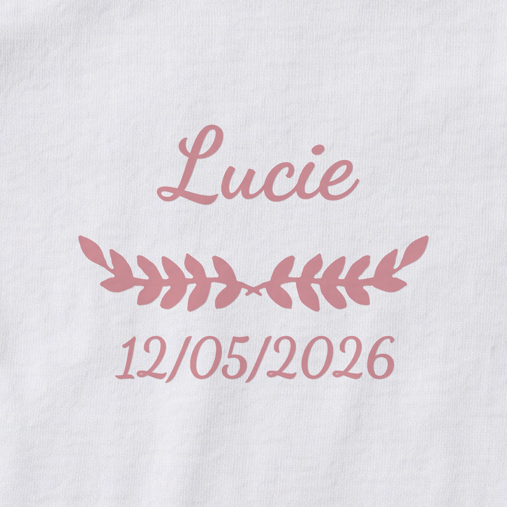 Body bébé personnalisé Lucie — gros plan du marquage « Lucie », ornement Feuillage et date de naissance « 12/05/2026 »