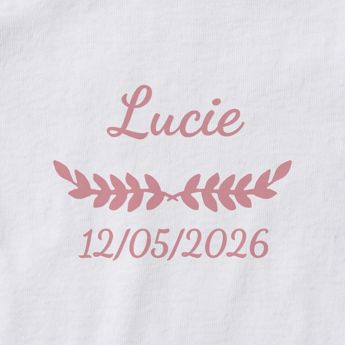 Body bébé personnalisé Lucie — gros plan du marquage « Lucie », ornement Feuillage et date de naissance « 12/05/2026 »
