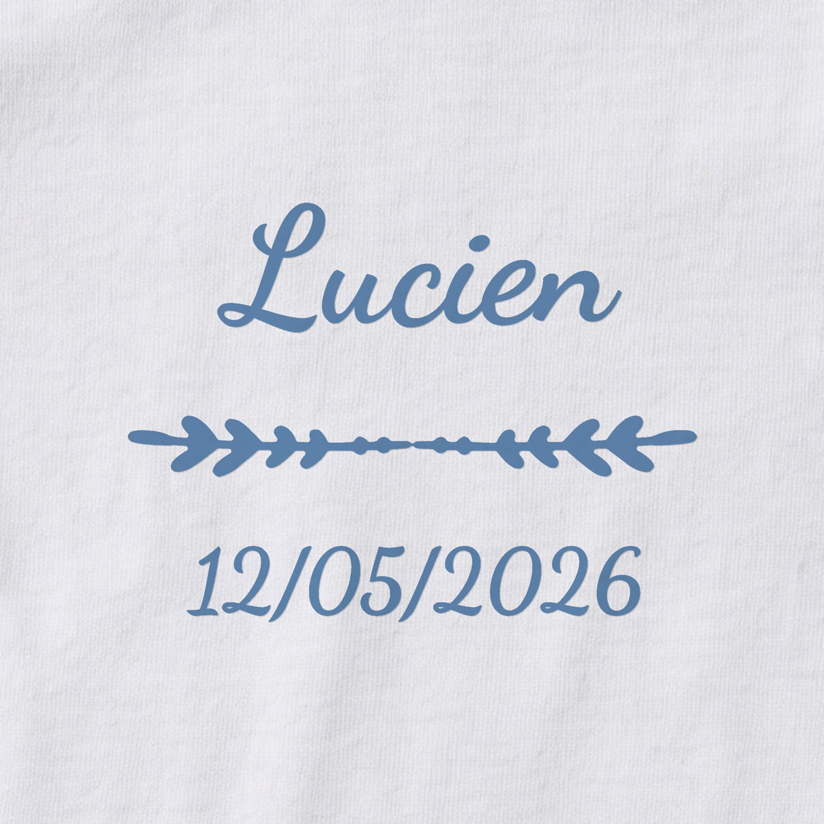 Body bébé personnalisé Lucien — gros plan du marquage « Lucien », ornement Flèche et date de naissance « 12/05/2026 »