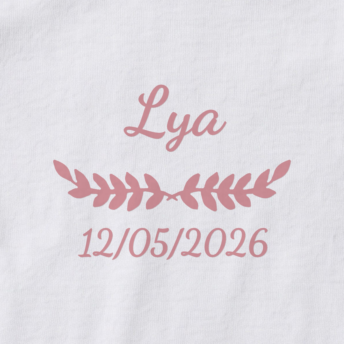 Body bébé personnalisé Lya — gros plan du marquage « Lya », ornement Feuillage et date de naissance « 12/05/2026 »