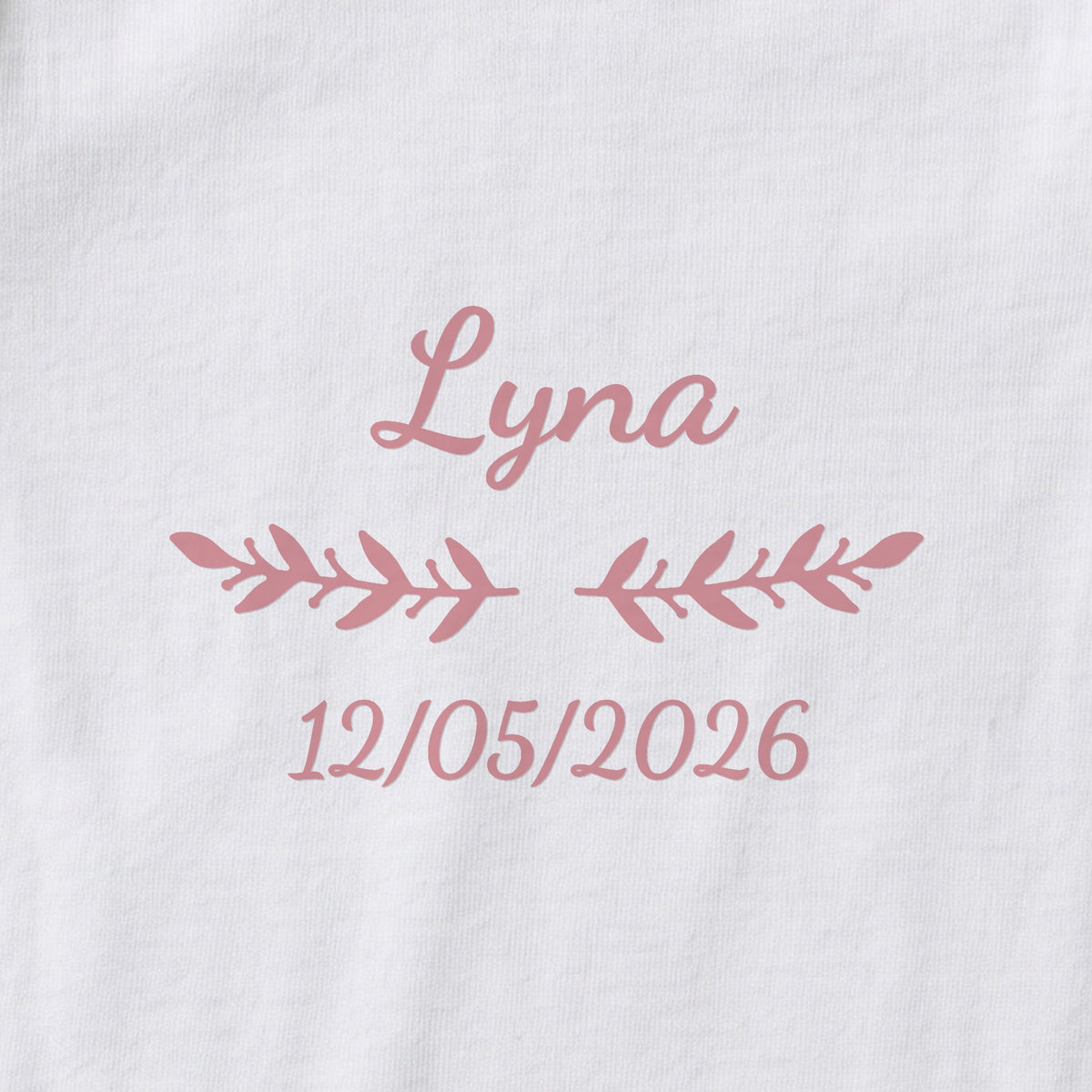 Body bébé personnalisé Lyna — gros plan du marquage « Lyna », ornement Rameaux et date de naissance « 12/05/2026 »