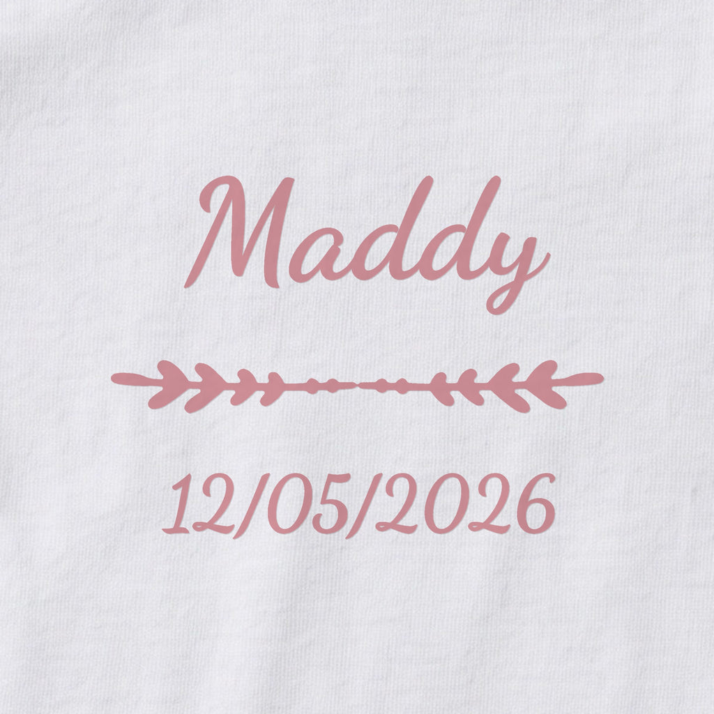 Body bébé personnalisé Maddy — gros plan du marquage « Maddy », ornement Flèche et date de naissance « 12/05/2026 »