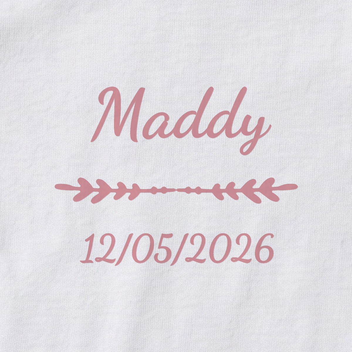 Body bébé personnalisé Maddy — gros plan du marquage « Maddy », ornement Flèche et date de naissance « 12/05/2026 »