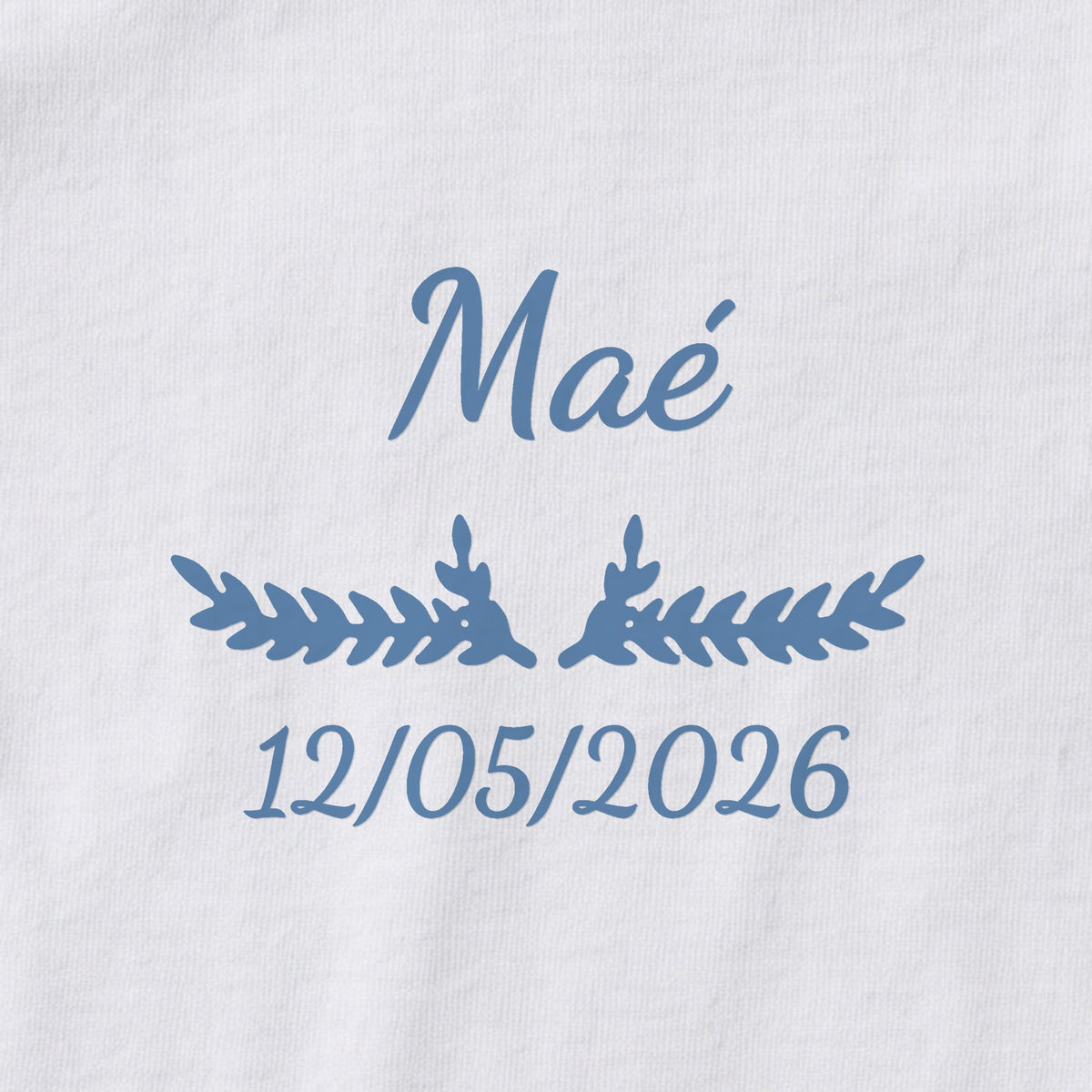 Body bébé personnalisé Maé — gros plan du marquage « Maé », ornement Bouquet et date de naissance « 12/05/2026 »