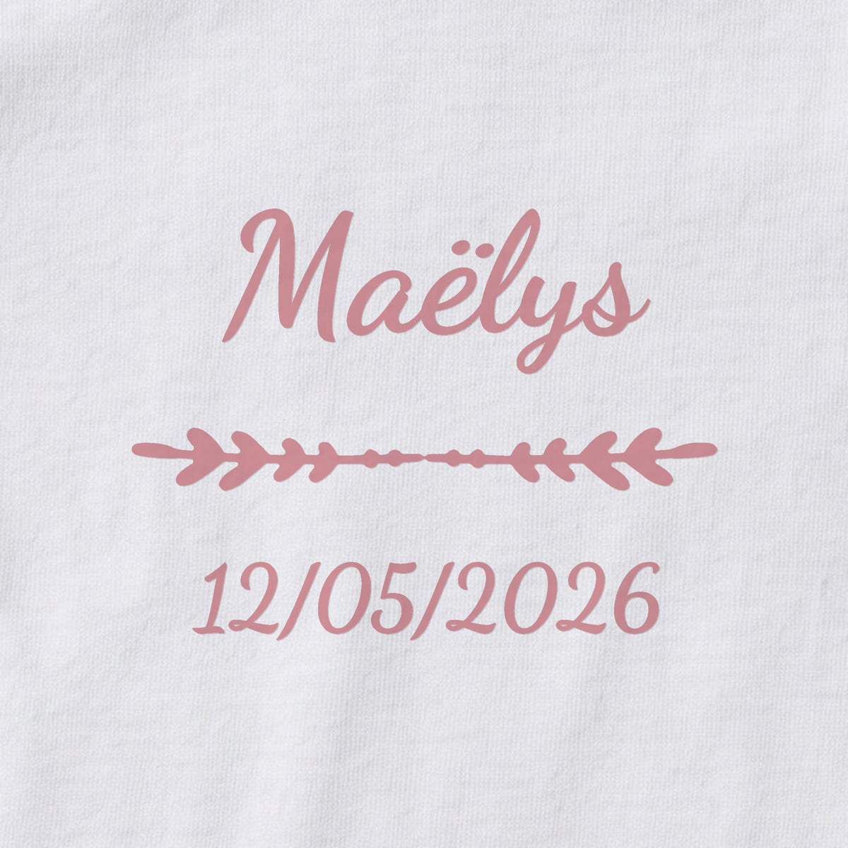 Body bébé personnalisé Maëlys — gros plan du marquage « Maëlys », ornement Flèche et date de naissance « 12/05/2026 »