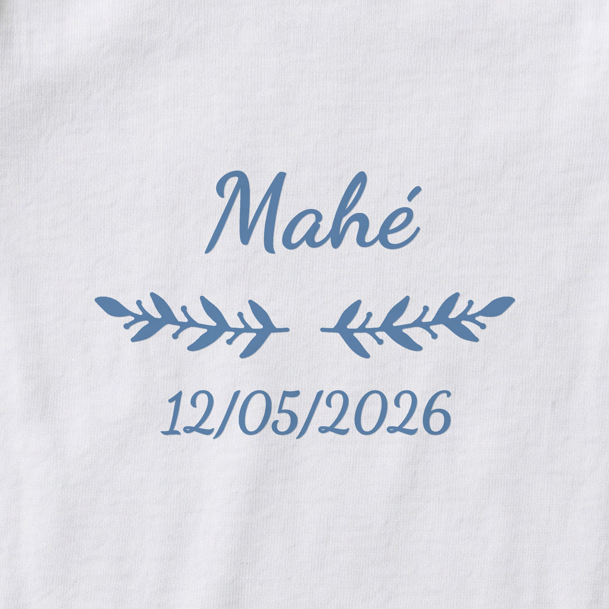 Body bébé personnalisé Mahé — gros plan du marquage « Mahé », ornement Rameaux et date de naissance « 12/05/2026 »