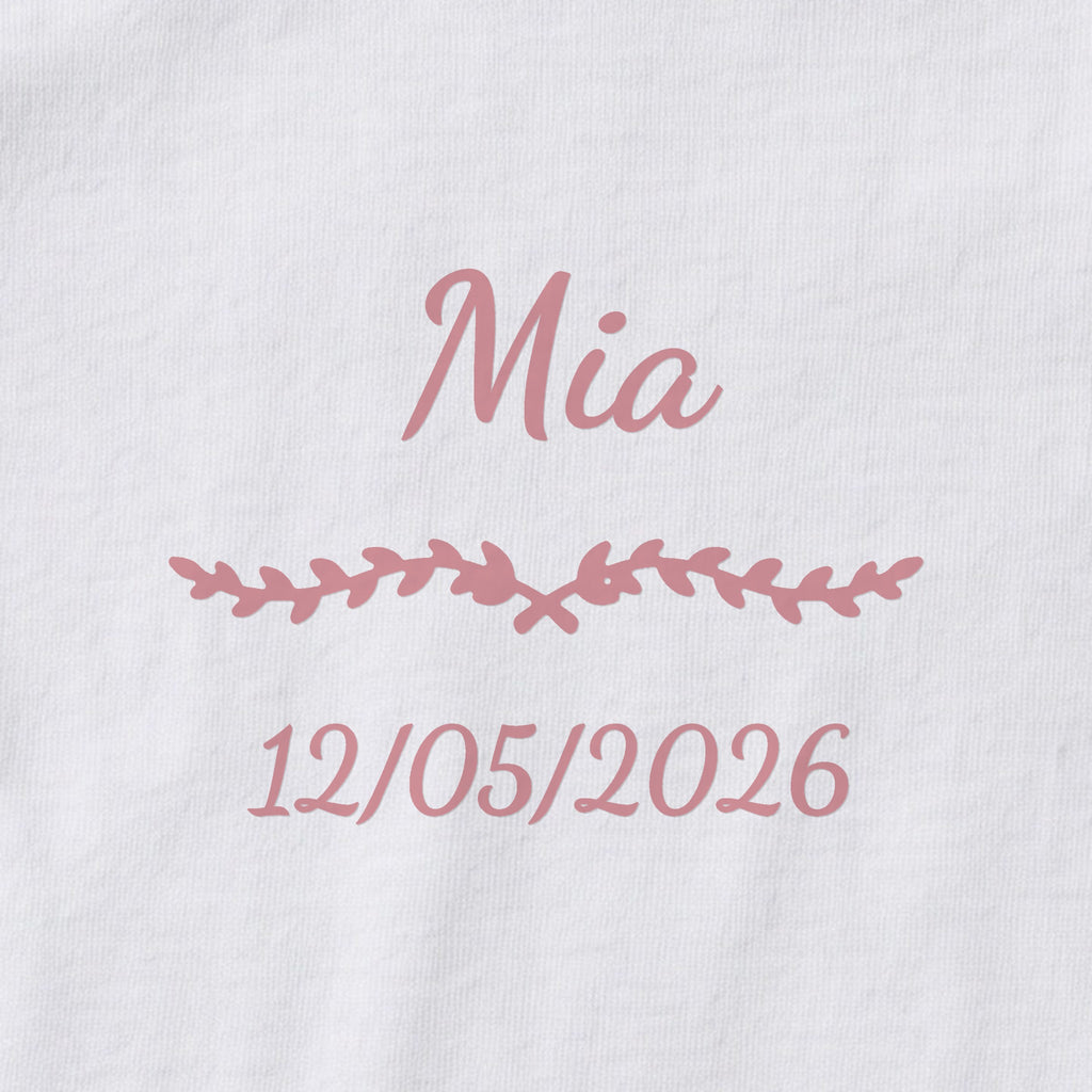 Body bébé personnalisé Mia — gros plan du marquage « Mia », ornement Liane et date de naissance « 12/05/2026 »