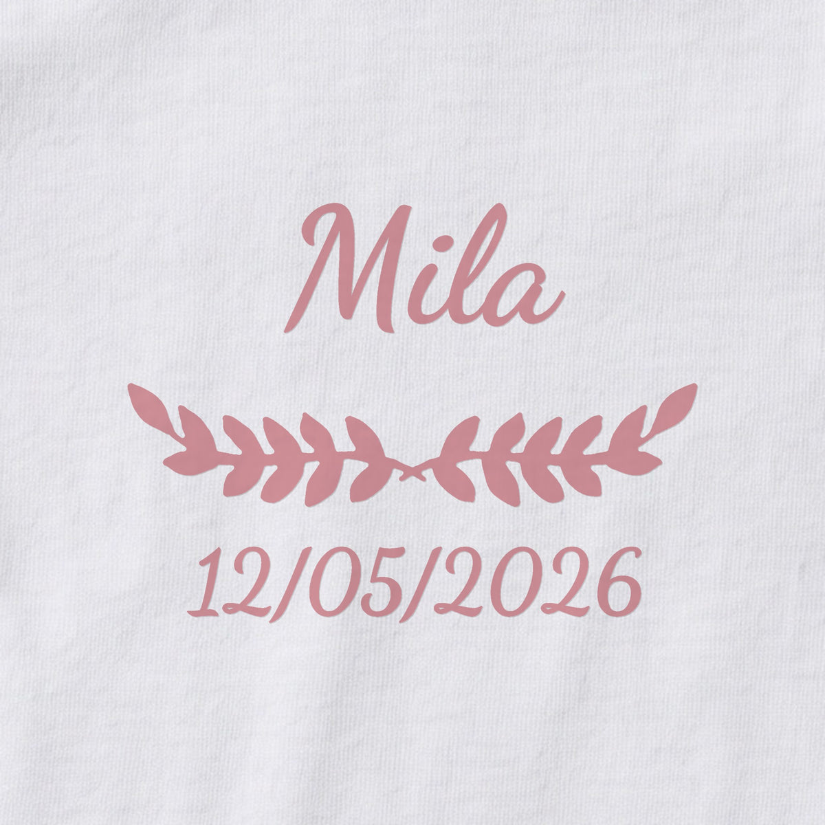 Body bébé personnalisé Mila — gros plan du marquage « Mila », ornement Feuillage et date de naissance « 12/05/2026 »
